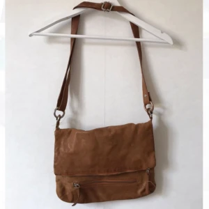  - Väska i ljust brunt skinn från Wera. Viks ned och knäpps. Många fack både utanpå och inuti väskan. Öljetter vid fäste behöver limmas, men inget jag tycker stör. Bruksskick, men fräsch!  Kan mötas i Stockholm eller skicka mot fraktkostnad! ✨🌸✨