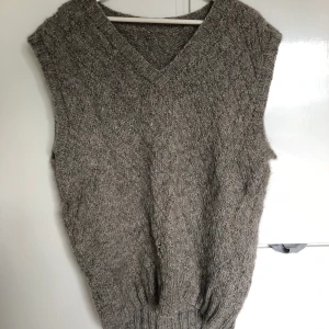 Stickad väst - En grå stickad väst, oversized. Ett mindre hål framtill. SAMFRAKTAR