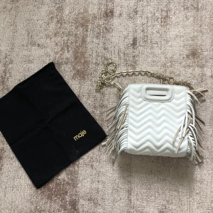 Maje väska  - Mycket fint skick Maje väska i den minsta modellen, slutsåld både online och i butik.  Nyp ca 2700kr. Båda banden medföljer, samt kvitto,dustbag,tags m.m
