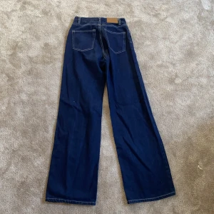 Mörkblå jeans med sömmar - Säljer dessa jeans med sömmar. Jättecoola med vidare ben. Jeansen är från Monki. Frakt tillkommer