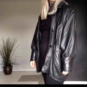 Längre skinnjacka  - Bikerjacka/skinnjacka i äkta skinn. Har lite axelvaddar. Är ifrån 80/90 talet, men i fint skick - inget jag direkt kan anmärka på.  Köparen stå för frakten, eller möts upp i Växjö området. 