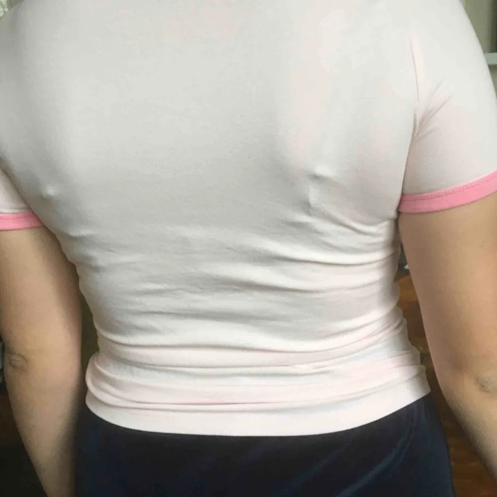 Ljusrosa t-shirt, slim fit. Tryck på bröstet: Feminist. Nyskick. . T-shirts.