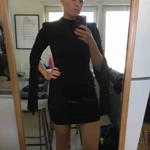 - Svart tight klänning med snygga armar och snygg rygg. Små axelpuffar som markerar armarna snyggt. Aldrig använd. Säljaren står för frakten 👗✨