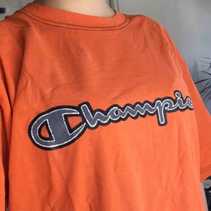  - Orange Champion t-shirt köpt på Humana! Jättehärlig och mysig🥰 Kan även användas som klänning! Jag brukade knyta den eller stoppa i den i byxorna. Frakt ej inkl.