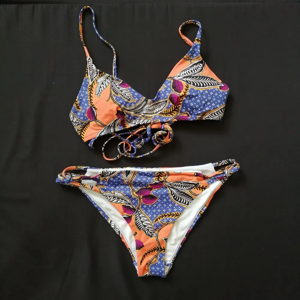 Floral bikini in orange/blue/purple colors. Bought from H&M couple of years ago but worn few times. In very good condition. Size S, regular fit and removable padding. . Övrigt.