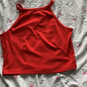 Rött linne, rändigt material, storlek M köparen står för frakten