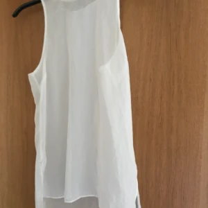 Genomskinligt linne - bik bok - I gott skick, aldrig använd, stretch runt halsen, slitsar vid sidorna. Väldigt genomskinligt.