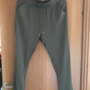 Gröna mjukisliknande - Ett material som är svårt att förklara, rätt glansigt material men i mjukismaterial. Säljer för att dem är för små. Stretch i midjan. Storlek M