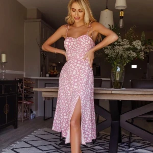 Rosa klänning med vita blommor - Super fin klänning som är oanvänd förutom att jag har testat den. Jag säljer den då den är för liten runt vid brösten. Storleken är i S/M. 💞