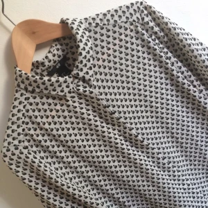  - Supersnygg kortärmad skjorta med mönster. Storlek 36 köpt på h&m. Kortare i modellen. 
Liten defekt på den silvriga knappen högst upp. 