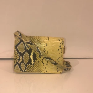 Gul ormskinns crossbody bag - Gul ormskinns crossbody bag från vero Moda. Aldrig använd. Fett cool! Ny pris -400kr