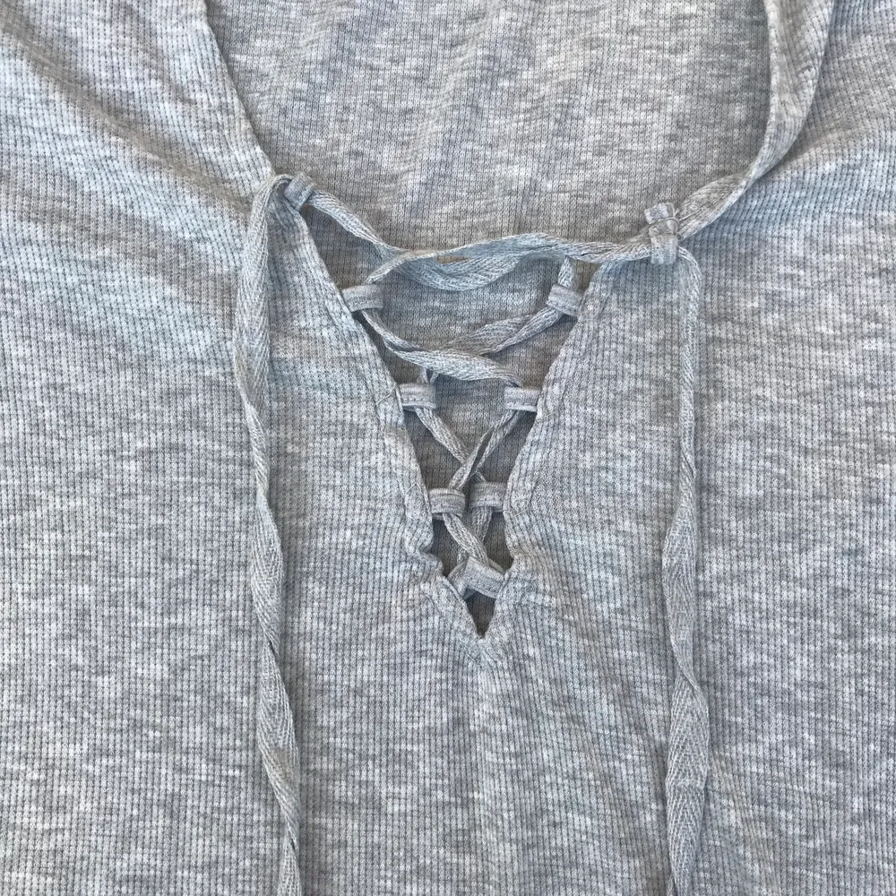 En fin grå t-shirt med snörning ifrån Gina Tricot i storlek S. Har endast använt den någon gång så den är i bra skick. (Frakten ingår i priset). T-shirts.