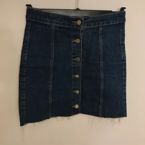 Jeanskjol stl 36 - 🌸Jeanskjol med knappar hela vägen framtill i stl 36 från Ginatricot. Slitningar nertill. Använd fåtal gånger, fint skick! Kan skickas, köparen står för frakten.🌸