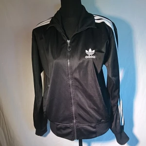 Adidaströja/jacka - Adidas-jacka i superfint skick. Storlek XL men passar jättebra på mindre också. Mycket fint skick. 