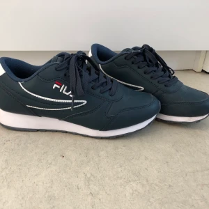 Fila skor storlek 37 - Fila skor i marin blå, storlek 37. Endast använda 2-3 gånger. Inga märken mer än det lilla på det vita som du ser på sista bilden. 