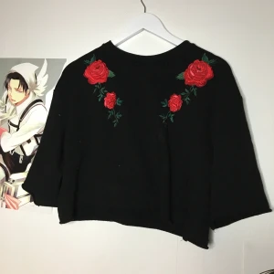 Svart croptop med rosor. Strl: S - Så sad... älskar denna verkligen men passar inte min stil. //// Skriv gärna om du vill ha mer bilder/bilder med plagget på - hade inte möjligheten att ta bild med alla plagg på :) TVÄTTAS EFTER BILD TAGEN kramiskrambjörn på dig