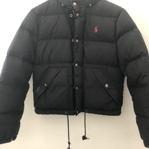 Polo Ralph Lauren dunjacka  - Dunjacka från Ralph Lauren i väldigt fint skick! Storlek M, Högsta bud: 365kr, frakt tillkommer! Budgivningen avslutas sön 4/10, 18:00