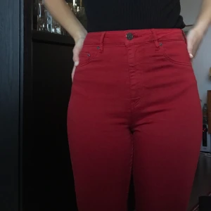 Röda skinny jeans  - Röda tighta stretchjeans. Jättesköna och mjuka att röra sig i. Höga i midjan. Har klippt av byxbenen lite men är snygga uppvikta. Storlek 28, passar mig som har S perfekt, stretchiga i midjan. 