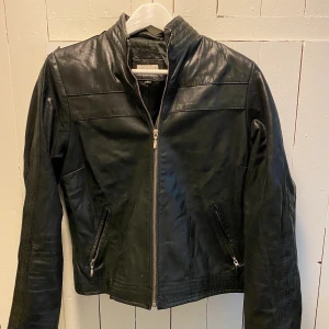 100% läderjacka i strl L - En svart äkta läderjacka som är väldigt fräsh och trendig. Strl Large.