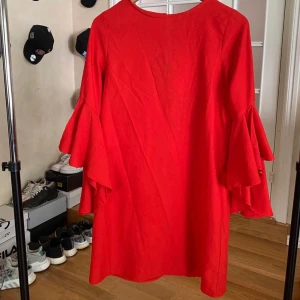 Röd volangklänning från Zara  - Röd klänning med volangärm från zara! Sparsamt använd och såå snygg. Frakten är spårbar 🥰