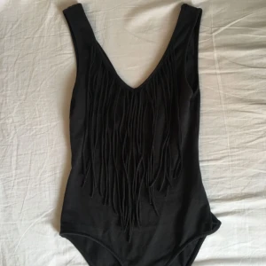  - Svart/mörkgrå fransbody från HM divided i storlek S men passar också xs. Bodyn har knäppning. Möts upp i Stockholm :)
