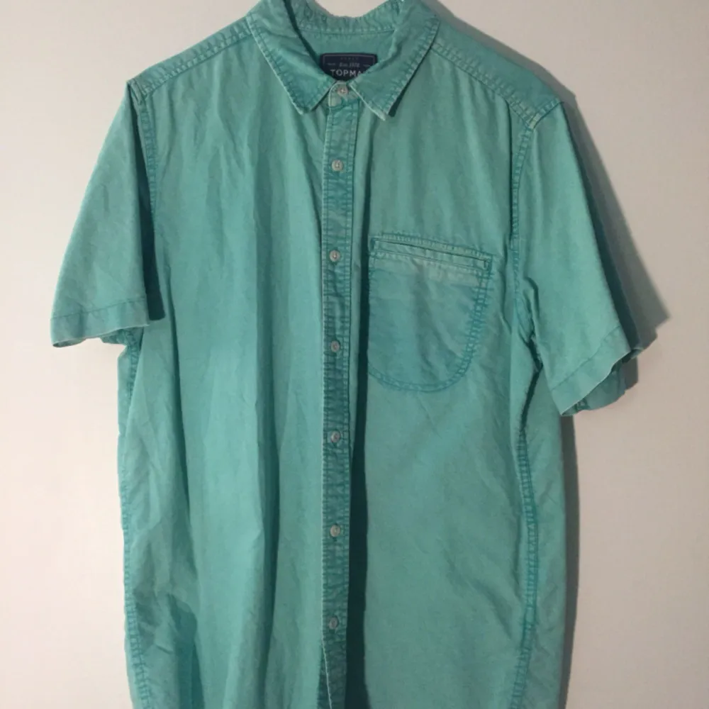 Grönblå kortärmad skjorta, tvättad färg, hel och ren.. Skjortor.