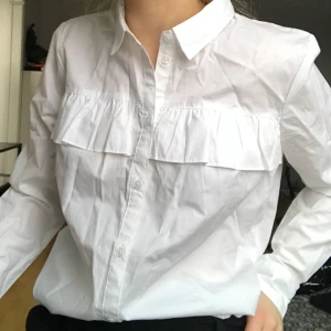  - Skjorta från hm med volang. Aldrig använd. Möts upp i Stockholm annars tillkommer frakt! 