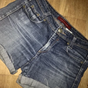  - Mörkblåa avklippta Levis-shorts.  Avklippta från jeans och därför tajtare runt låren. (på bilden är dem uppvikta) I bra skick, låg midja.  Köparen står för frakten.
