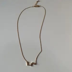 Guldigt halsband med ”diamanter” som formar Karlavagnen.