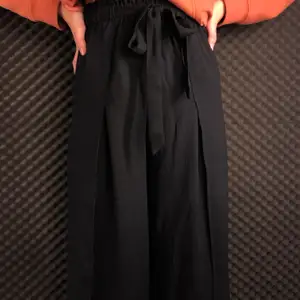 Fina svarta kostymbyxor med knyte vid midjan o slits. Köpa från bikbok i fint skick. Stl 34. Frakt ingår