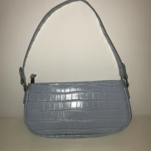 Baby blå axelväska💙 - En babyblå Axelväska med krokodilmönster, köpt på Shein i somras knappt använd och i mycket bättre kvalitet än man tror den har inga skador och är inte sönder nånstans. Buda gärna i kommentarerna🥰🥰    Köpare står för frakten 
