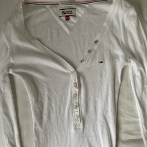 Tommy Hilfiger Tröja - En super fin tröja som ger en jätte fin passform över bysten, går att reglera urringningen med knapparna. Tröjan är från Tommy Hilfiger och är i storlek XS. Buda gärna :)