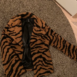 Teddy jacka - Teddy jacka i tigermönster med vida armar. Slutar under höften. Är 170 cm lång. 