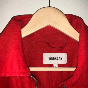 Röd jeansjacka från Weekday - Storlek S. Använd fåtal gånger. Röd jeansjacka med en dragkedja och en ficka på vänster bröst. 