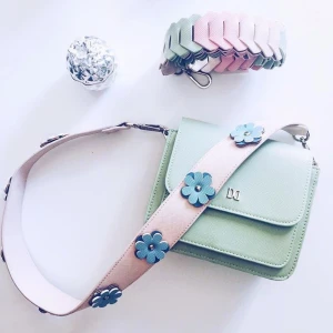  - Säljer min fina mintgröna handväska med ett blommigt axelband som är köpt separat! Den tillhörande axelbandet till väskan medföljer även! Den är i fint skick och prislapparna sitter kvar! Väskan är endast provad! Tyvärr kommer den aldrig till användning, så hoppas att någon annan där ute kan ha mer användning för den! 