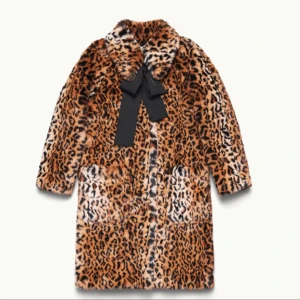  - ERDEM x H&M.  En rakt skuren kappa i mjuk pälsimitation med leopardmönster. Kappan har krage och avtagbart ripsband i nacken som knyts fram. Dolda tryckknappar samt utanpåfickor fram. 