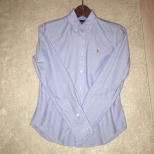 Säljer en ljusblå Oxford skjorta från Ralph lauren. Skjortan är endast använd ett fåtal gånger. Modellen är super slim fit och är i storlek 4 som både en XS och en S kan ha! 