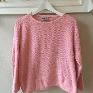 Rosa stickad tröja - Rosa stickad tröja i bomull med ”uppklippta” sidor.