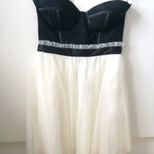  - Supersnygg axelbandslös klänning som slutar ovanför knäna. Innanför kuporna finns ett silikon/gummi-rem som gör att klänningen hålls upp bra! Oanvänd. S men passar även S/M. Passar perfekt till balen, studenten eller någon annan festlighet! Köparen står för frakten.