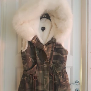  - Säljer nu min päls väst med millitär mönster de är vit päls i hela västen. I storlek 36. Fickan är sönder så de är ett stort hål. 