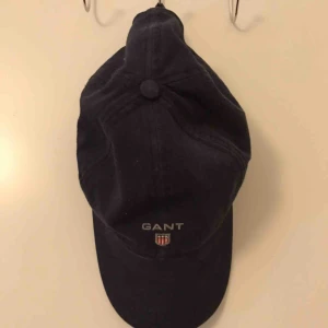  - Mörkblå Gant keps som inte används, går att ändra storlek bak. Kan mötas i Borås eller frakta, köparen står för frakt. 
