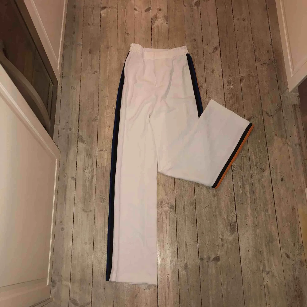 Högmidjade vita kostymbyxor med stripes på sidan från Zara i storlek M. Använda en gång på ett resturang besök i Prag i våras (så skulle ändå påstå att det är lite special). Stretchiga och ass najs passform med lite vidare ben!. Jeans & Byxor.