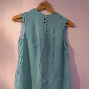  - Vintageklänning i turkos med klädda knappar och fin skurning