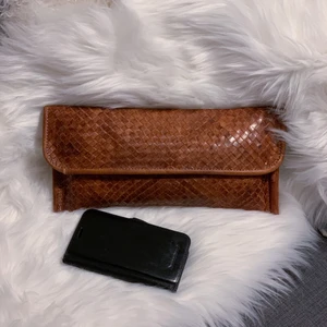 Handväska läder - Liten smidig väska i vävt läder. Handgjord i Portugal, där jag köpte den. Sparsamt använd. Litet fack inuti. Äkta läder. Mått: 32x15cm (mitt klumpiga mobilfordral är med som storleksguide)