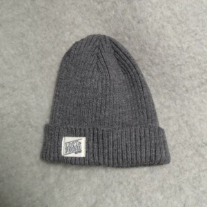  - Grå sotarmössa från Carlings av märket Lost & Found. Akryl och elstan. 