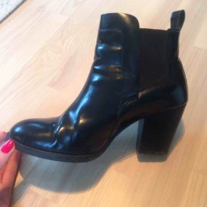  - Boots från H&M i äkta läder, blankt svarta. Bekväma och i bra skick. Storlek 39. En liten slitning på ena tån, se bild.   Ord pris 599kr.