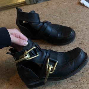  - Jeffrey Campbell Roscoe boots cut out. väl använda men blir bara snyggare! lite glapp i ena spännet, men ska enligt skomakare gå att spänna skruven. tyvärr ingen skolåda, köpta för 2200-2400kr minns ej exakt. Frakt tillkommer! 