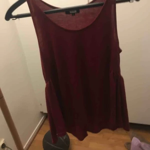  - En vinröd blus, men små detaljer.