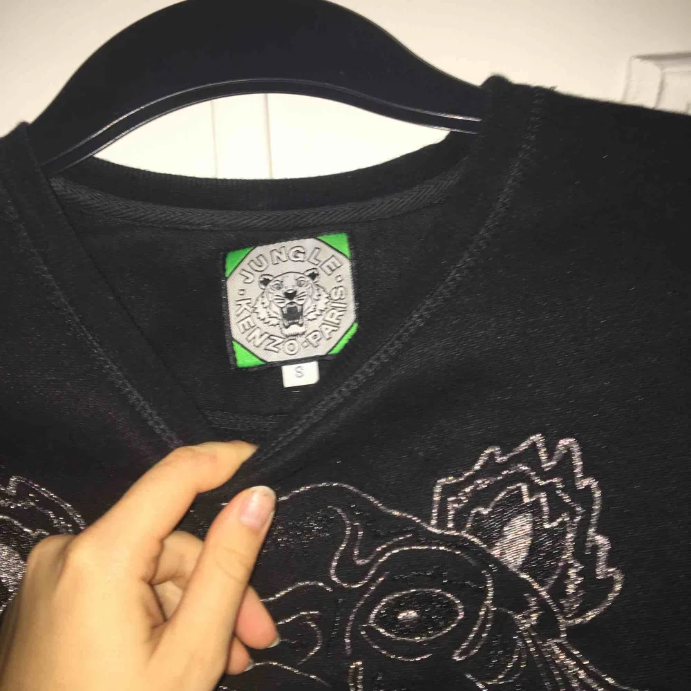 Svart Kenzo sweatshirt med silver detaljer. Ganska liten i storleken, funkar definitivt som en XS. Inga defekter men den är väl använd! Priset kan diskuteras och jag kan mötas upp i Stockholm💗. Hoodies.