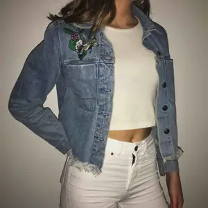 Cropad jeans jacka från h&m’s collektion Coachella! Blommigt broderi och bröstfickor.